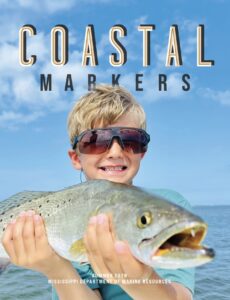cover of magazine showing a boy holding a fish with a background of water